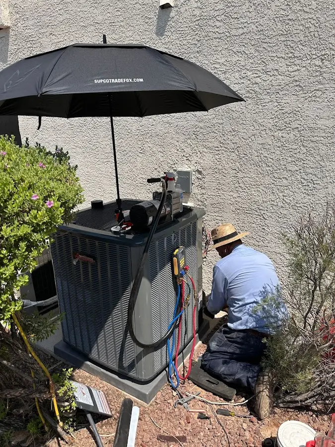 HVAC technician performing outdoor AC maintenance in McCordsville