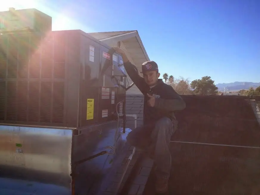 HVAC technician performing Air Duct Cleaning on a rooftop unit in McCordsville